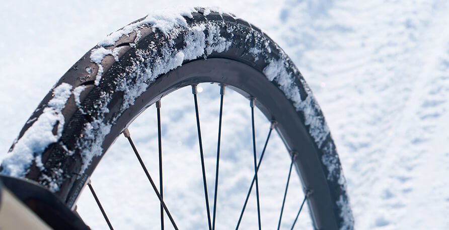 Een fietsband die vol zit met sneeuw